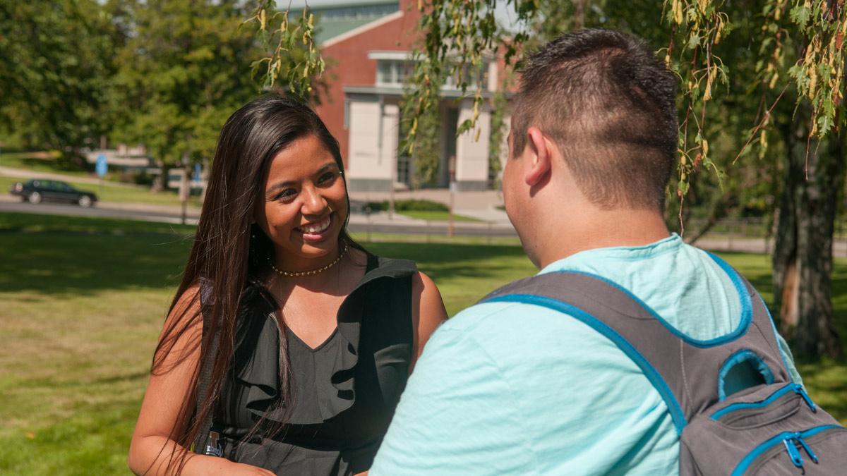 Two students talk on the Admin Lawn.