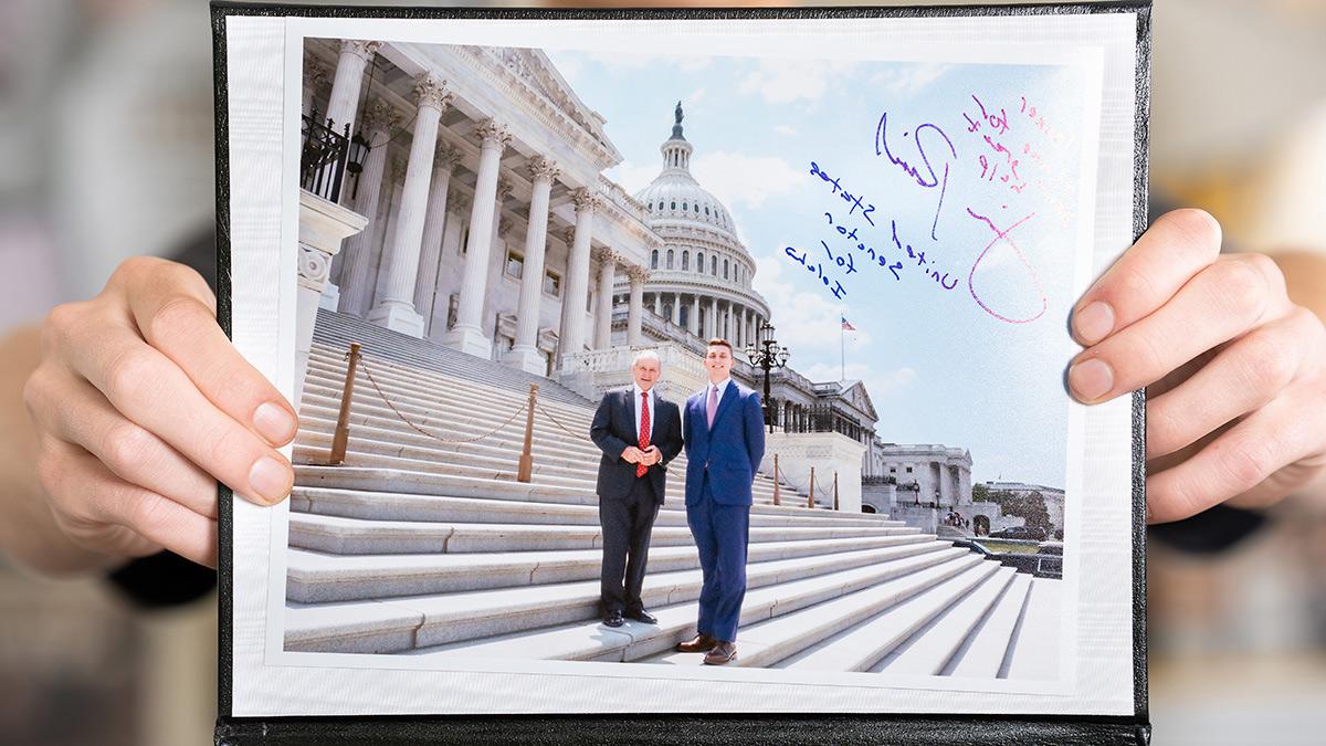 Two hands hold picture and plaque.